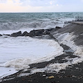 Mare agitato a Maiori: le onde trasportano schiuma bianca sulla spiaggia /FOTO